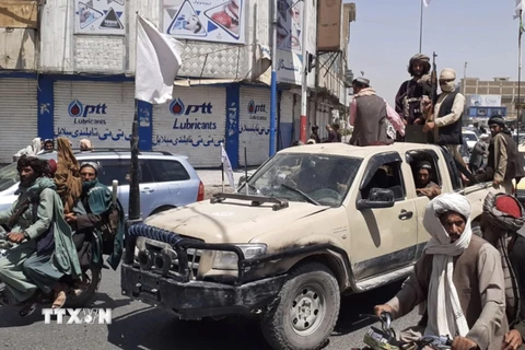 Các tay súng Taliban giương cờ trắng, biểu tượng khi lực lượng này chiếm được thành phố Kandahar, Afghanistan ngày 13/8. (Ảnh: PM News/TTXVN)