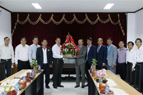 Đại sứ Nguyễn Bá Hùng tặng hoa cho đại diện các cơ quan báo chí Lào, chúc mừng 71 năm ngày thành lập báo chí Lào. (Ảnh: Thu Phương/TTXVN)