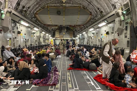 Người dân Afghanistan bên trong máy bay quân sự Mỹ, chuẩn bị được sơ tán khỏi sân bay quốc tế ở Kabul. (Ảnh: AFP/TTXVN)
