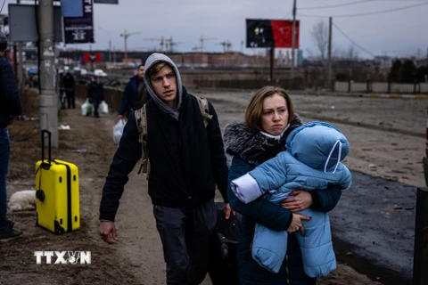 Người dân sơ tán khỏi thành phố Irpin, phía Tây Bắc Kiev, Ukraine ngày 7/3. (Ảnh: AFP/TTXVN)