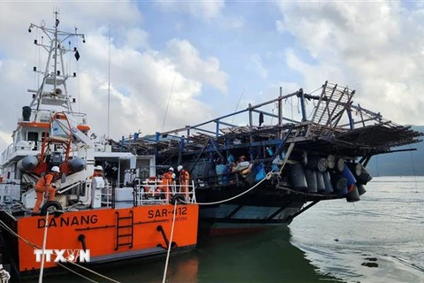 Tàu SAR 412 lai dắt tàu cá bị nạn cập bờ an toàn. (Ảnh: TTXVN phát)