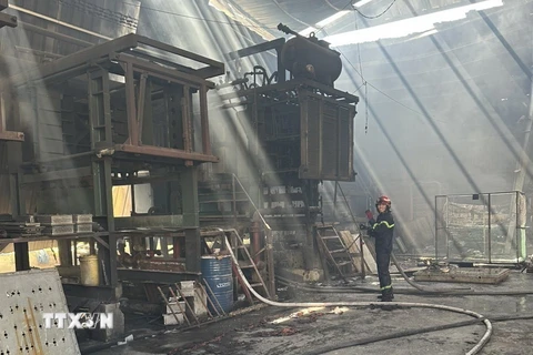 Lực lượng chức năng kịp thời khống chế đám cháy tại công ty mút xốp 4.000m2. (Ảnh: TTXVN phát)