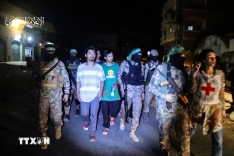 Hình ảnh chụp qua video cho thấy các tay súng Hamas trao trả con tin Thái Lan cho Ủy ban Chữ thập Đỏ Quốc tế tại Dải Gaza, ngày 26/11. (Ảnh: AFP/TTXVN)