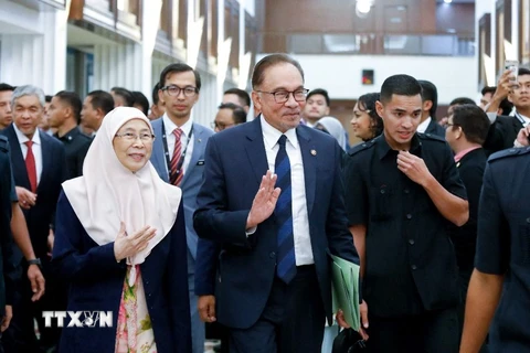 Thủ tướng Malaysia (giữa) rời phiên họp Hạ viện sau cuộc đánh giá tín nhiệm, ở Kuala Lumpur. (Ảnh: AFP/TTXVN)