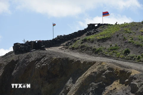 Quốc kỳ Azerbaijan (trái) và Quốc kỳ Armenia tại trạm kiểm soát biên giới giữa hai nước ở làng Sotk (Armenia). (Ảnh: AFP/TTXVN)