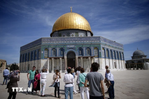 Khách du lịch chụp ảnh bên ngoài Thánh đường Hồi giáo tại thành cổ Jerusalem. (Ảnh: AFP/TTXVN)