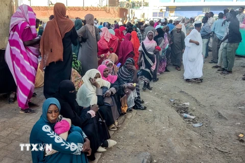 Người dân xếp hàng chờ nhận hàng cứu trợ tại Gedaref, Sudan. (Ảnh: AFP/TTXVN)