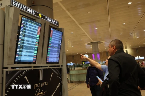Hành khách theo dõi danh sách các chuyến bay bị hủy trên bảng thông báo tại sân bay . (Ảnh minh họa. AFP/TTXVN)