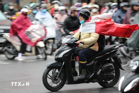 Người dân Hà Nội di chuyển trong mưa, rét. (Ảnh: Thanh Tùng/TTXVN)