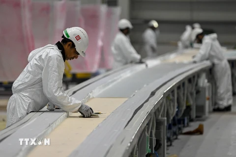 Công nhân làm việc tại một nhà máy ở Mundra, Ấn Độ. (Ảnh: AFP/TTXVN)