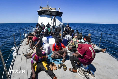 Người di cư được giải cứu lên tàu của Lực lượng bảo vệ bờ biển Tunisia, trên vùng biển giữa Tunisia và Italy. (Ảnh: AFP/TTXVN)