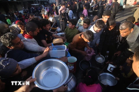 Người dân chờ được phát thực phẩm cứu trợ tại thành phố Rafah, Dải Gaza. (Ảnh: THX/TTXVN)