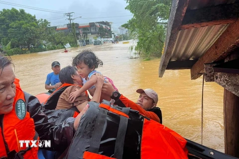 Lực lượng cứu hộ sơ tán em nhỏ khỏi vùng ngập lụt tại thị trấn Catarman, Philippines,. (Ảnh minh họa. AFP/TTXVN)