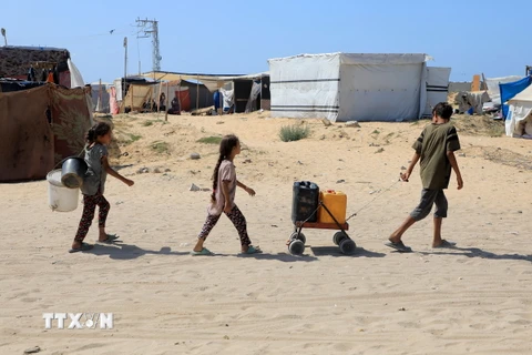 Trẻ em lấy nước sinh hoạt tại thành phố Khan Younis, Dải Gaza ngày 10/6/2024. (Ảnh: THX/TTXVN)
