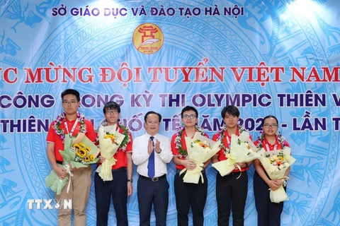 Giám đốc Sở Giáo dục và Đào tạo Hà Nội Trần Thế Cương chúc mừng và tặng giấy khen cho các học sinh. (Ảnh: Thanh Tùng/TTXVN)