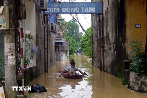 Người dân xã Đồng Bẩm, thành phố Thái Nguyên phải di chuyển bằng thuyền. (Ảnh: Thu Hằng/TTXVN)