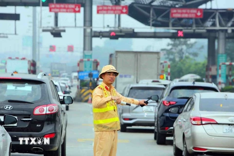 Cảnh sát giao thông điều tiết, phân luồng giao thông đoạn trạm thu phí cao tốc Pháp Vân-Cầu Giẽ. (Ảnh: Phạm Kiên/TTXVN)