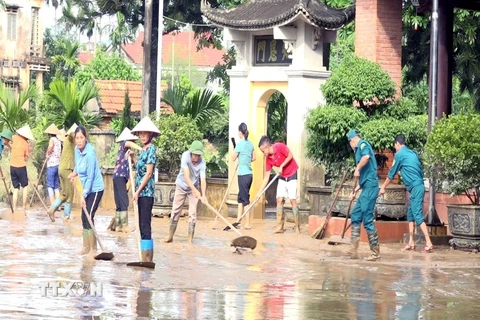 Người dân và các cơ quan chức năng thị trấn Cẩm Khê, huyện Cẩm Khê nỗ lực khắc phục hậu quả sau lũ. (Ảnh: Tạ Toàn/TTXVN)