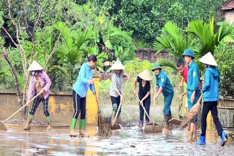 Người dân và các cơ quan chức năng thị trấn Cẩm Khê, huyện Cẩm Khê nỗ lực khắc phục hậu quả sau lũ. (Ảnh: Tạ Toàn/TTXVN)