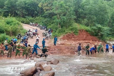 Các lực lượng san lấp, bồi đắp các đoạn bị hư hỏng, xói lở sau bão số 4. (Ảnh: TTXVN phát)