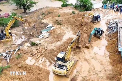 Lực lượng chức năng triển khai xử lý hàng chục ngàn m3 đất đá để sớm thông tuyến Quốc lộ 2. (Ảnh: TTXVN phát.)