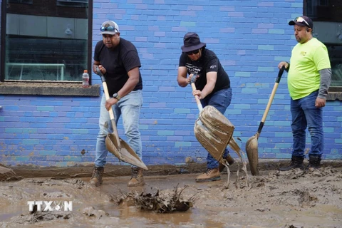 Người dân dọn bùn sau khi bão Helene quét qua ở Asheville, bang North Carolina, Mỹ. (Ảnh: Kyodo/TTXVN)