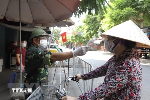 Lực lượng chức năng tại Thị trấn Phùng, huyện Đan Phượng, Hà Nội kiểm soát chặt chẽ người đi chợ dịp nghỉ lễ Quốc khánh. (Ảnh: Minh Quyết/TTXVN)