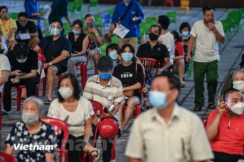Để kịp hoàn thành tiêm vaccine cho 100% người dân trên địa bàn, quận Hoàn Kiếm đã tổ chức điểm tiêm đến đêm tại Cung Văn hóa Hữu nghị Việt Xô. (Ảnh: PV/Vietnam+)
