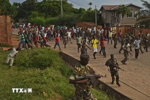 Binh sỹ Burundi cố gắng duy trì an ninh trong khi biểu tình diễn ra tại Musaga, ngoại ô thủ đô Bujumbura ngày 20/5. (Nguồn: AFP/TTXVN)