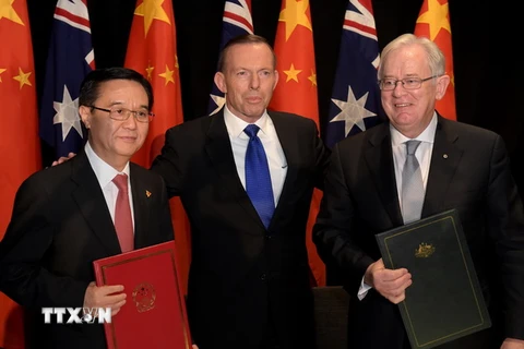 Bộ trưởng Thương mại Trung Quốc Cao Hổ Thành (trái), Thủ tướng Australia Tony Abbott (giữa) và Bộ trưởng Thương mại Australia Andrew Robb (phải) tại lễ ký kết. (Nguồn: AFP/TTXVN)