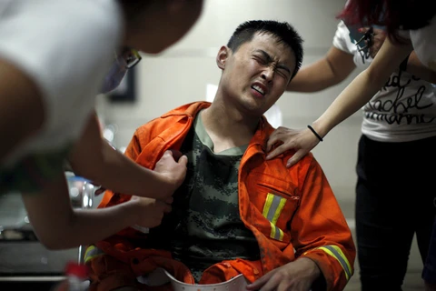 Một người lính cứu hỏa đang được sơ cứu ở bệnh viện sau vụ nổ ở Thiên Tân. (Nguồn: Reuters)