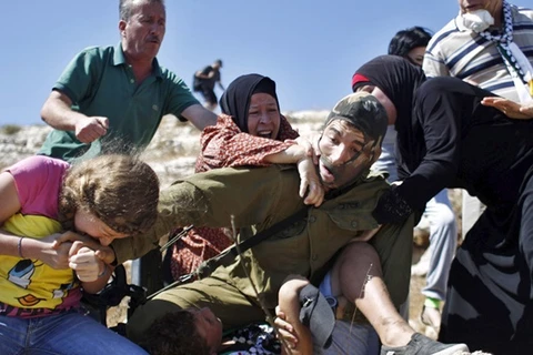 Người lính Israel bị gia đình cậu bé tấn công. (Nguồn: RT)