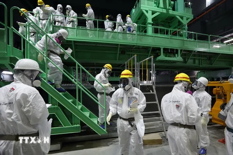 Các kỹ thuật viên hoàn tất công tác chuẩn bị trước khi di dời các thanh nhiên liệu ở nhà máy Fukushima 1. (Nguồn: AFP/TTXVN)