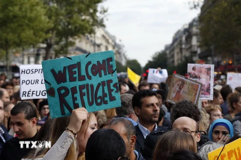 Người dân Pháp giương cao biểu ngữ 'Chào đón người di cư' trong cuộc tuần hành ủng hộ người di cư tại Paris ngày 5/9. (Nguồn: AFP/TTXVN) 