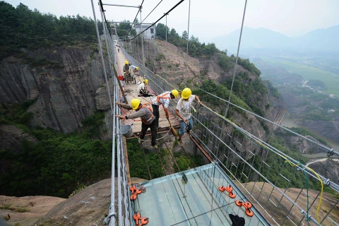 Một nhóm 11 công nhân đang làm việc để biến một cây cầu gỗ dài 300m thành cây cầu thủy tinh ở độ cao 180m.(Nguồn: CCTVNews)