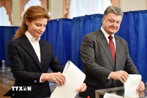 Tổng thống Ukraine Petro Poroshenko (phải) và phu nhân bỏ phiếu tại một địa điểm bầu cử ở Kiev. (Nguồn: AFP/TTXVN)