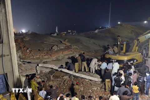 Lực lượng cứu hộ tìm kiếm các nạn nhân tại hiện trường vụ sập nhà.