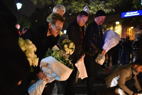 Ca sỹ Bono và nhóm nhạc U2 đặt hoa trên vỉa hè gần với rạp hát Bataclan.