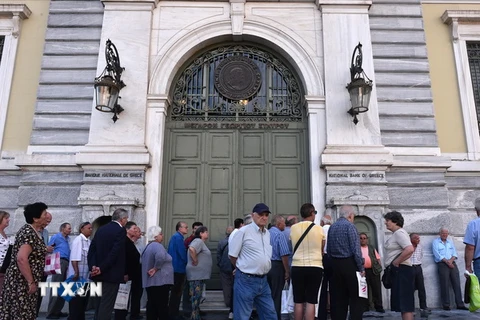 Người được hưởng trợ cấp và lĩnh lương hưu xếp hàng chờ đợi bên ngoài trụ sở Ngân hàng quốc gia Hy Lạp đã đóng cửa ở Athens ngày 29/6. (Nguồn: AFP/TTXVN) 