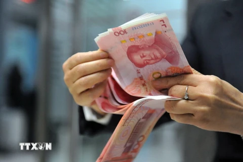 Nhân viên ngân hàng kiểm tiền 100 nhân dân tệ tại một ngân hàng ở Hàng Châu, tỉnh Chiết Giang, miền đông Trung Quốc.