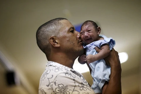 Geovane Silva đang bế con trai Gustavo Henrique mắc chứng đầu nhỏ ở bệnh viện Oswaldo Cruz (Brazil).