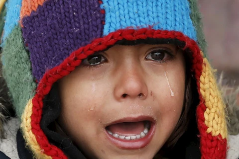 Một em bé khóc dưới giá lạnh trong trại tị nạn ở Presevo, Serbia.