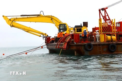 Giai đoạn thả cáp ngầm đang được triển khai từ đảo vào đất liền. (Ảnh: Ngọc Hà/TTXVN)