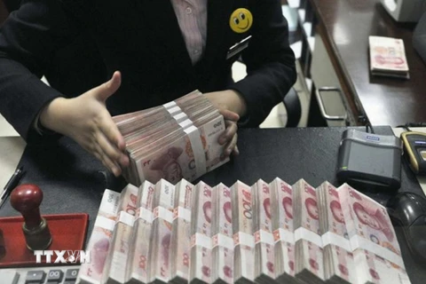 Kiểm đồng nhân dân tệ tại một ngân hàng ở Trung Quốc. (Nguồn: Reuter/TTXVN) 