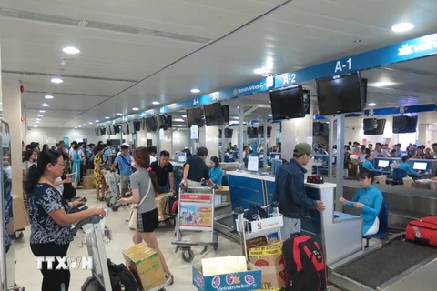 Hành khách đến làm thủ tục check in tại sân bay Tân Sơn Nhất. (Ảnh: Hoàng Hải/TTXVN) 