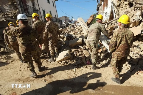 Lực lượng cứu hộ tìm kiếm nạn nhân động đất tại hiện trường đổ nát Italy ngày 26/8. (Nguồn: AFP/TTXVN) 