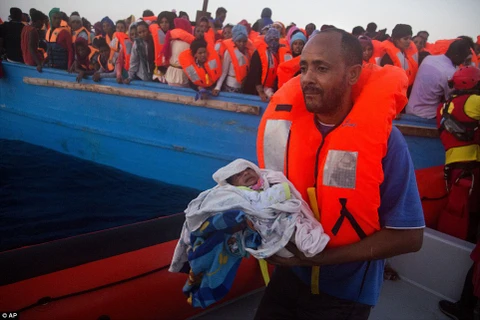 Một ông bố và con trai 5 ngày tuổi được giải cứu ở bờ biển Libya. (Nguồn: Dailymail)