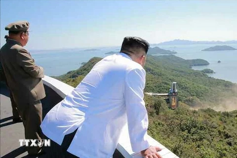 Nhà lãnh đạo Triều Tiên Kim Jong-un (phải) thị sát việc thử nghiệm trên mặt đất động cơ tên lửa công suất lớn tại Trung tâm vũ trụ Sohae, Triều Tiên. (Nguồn: Yonhap/TTXVN) 