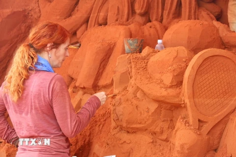 Nhà điêu khắc Marielle Heessels (Hà Lan) đang thực hiện điêu khắc một tác phẩm tượng cát. (Ảnh: Nguyễn Thanh/TTXVN)