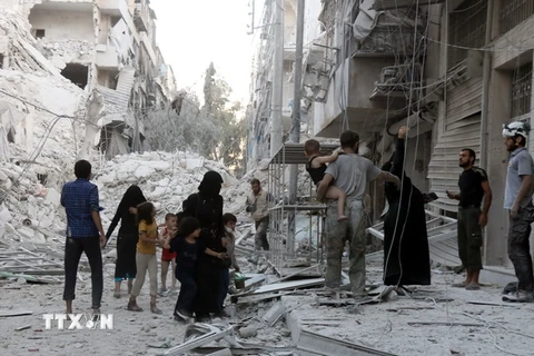 Người dân Syria chuyển thi thể các nạn nhân sau xung đột tại al-Muasalat, phía bắc thành phố Aleppo ngày 23/9. (Nguồn: AFP/TTXVN) 